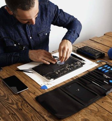master-uses-small-suction-cup-remove-battery-cells-from-broken-laptop-repair-clean-it-his-laboratory-with-special-tools-table-around-1024x683